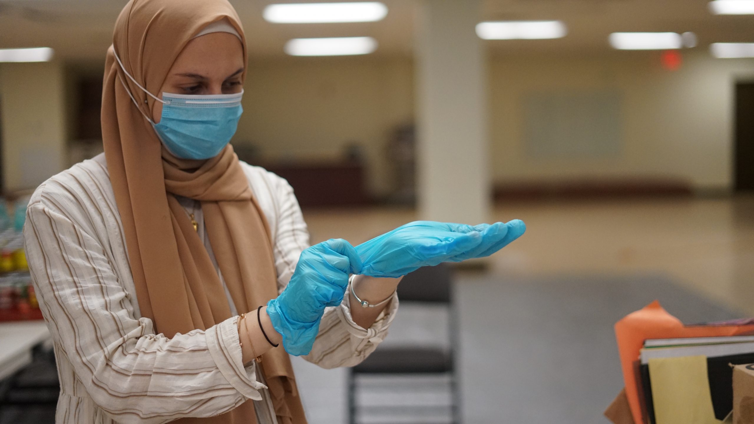 A volunteer puts on latex gloves